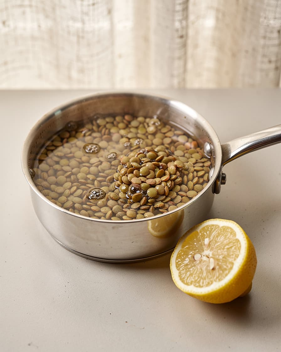 Steg 3: Värm linserna i en liten kastrull med en matsked vatten och hälften av citronsaften medan blomkålen rostar.